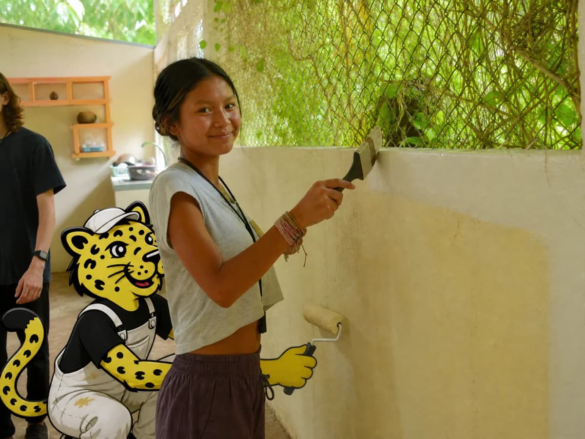 Painter rolling a wall while Leo paints the lower edge