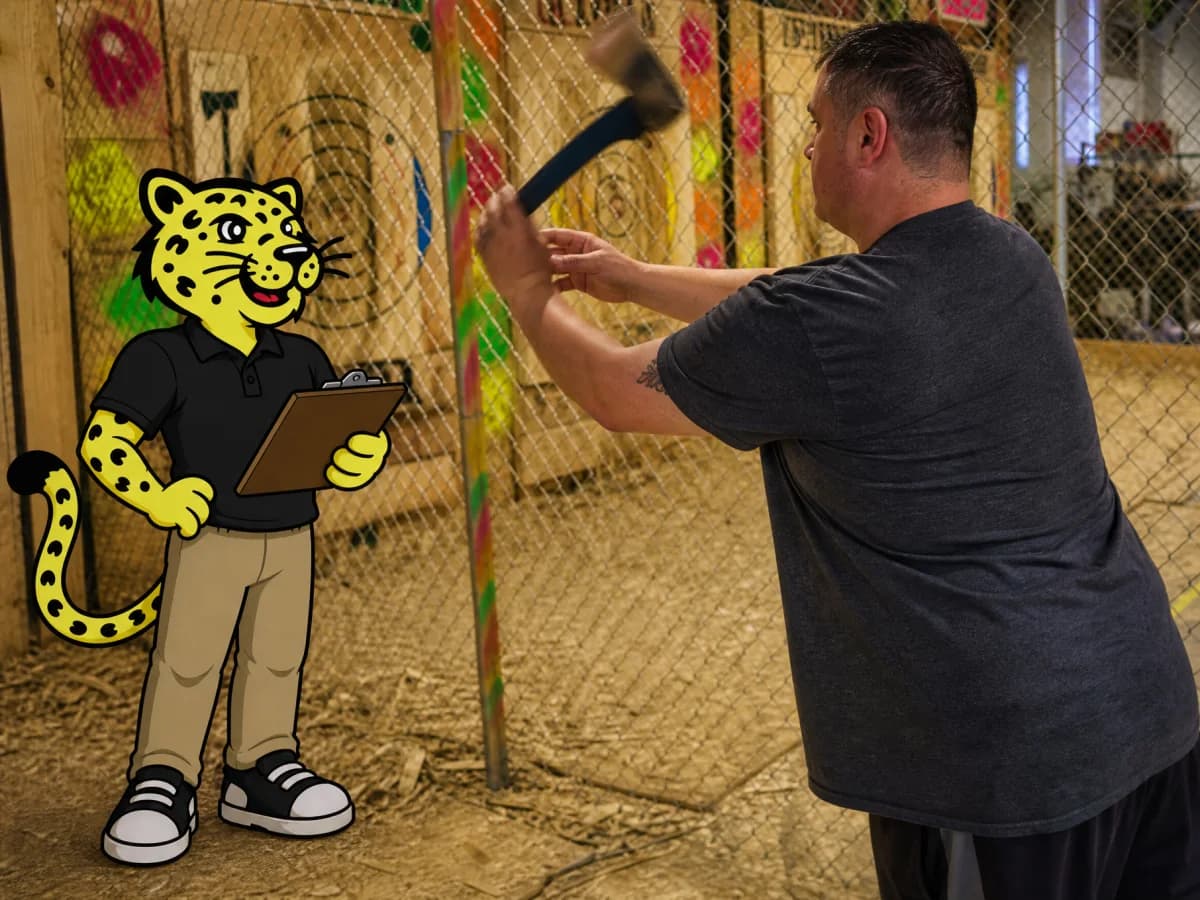 Axe throwing venue attendant observing a guest beside Leo with a clipboard