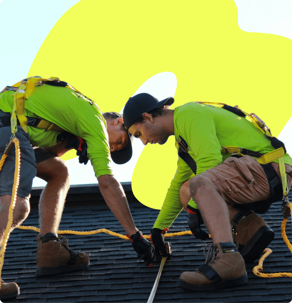 Two employees working safely together on a roofing project