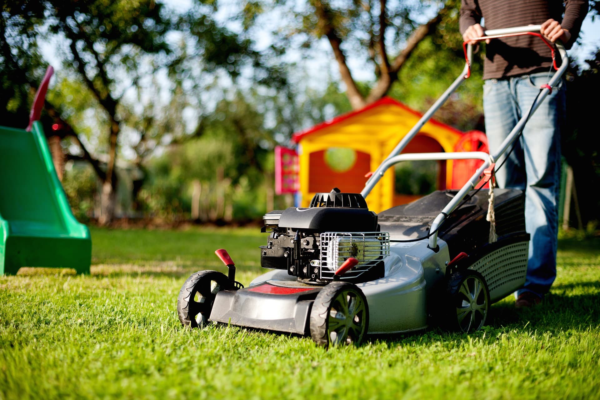 Lawn care worker mowing grass